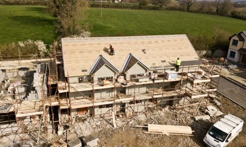 pexels-photo-2098624-2098624-1 Aerial shot of a house under construction in Clonmel, Ireland. Workers on the roof.
